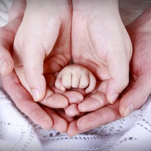 hands of parents and newborn baby